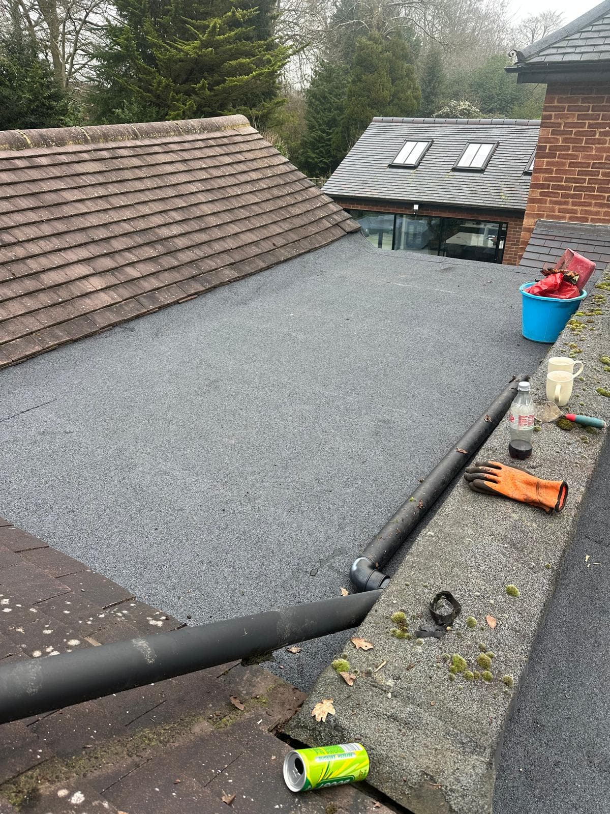 Finished grey GRP fibreglass balcony roof with continuous upstands, flower boxes on the railing behind